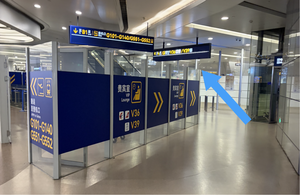 上海浦東国際空港ターミナル1の保安検査後エリアにあるV36・V39ラウンジへの案内看板と進む方向を示す青い矢印