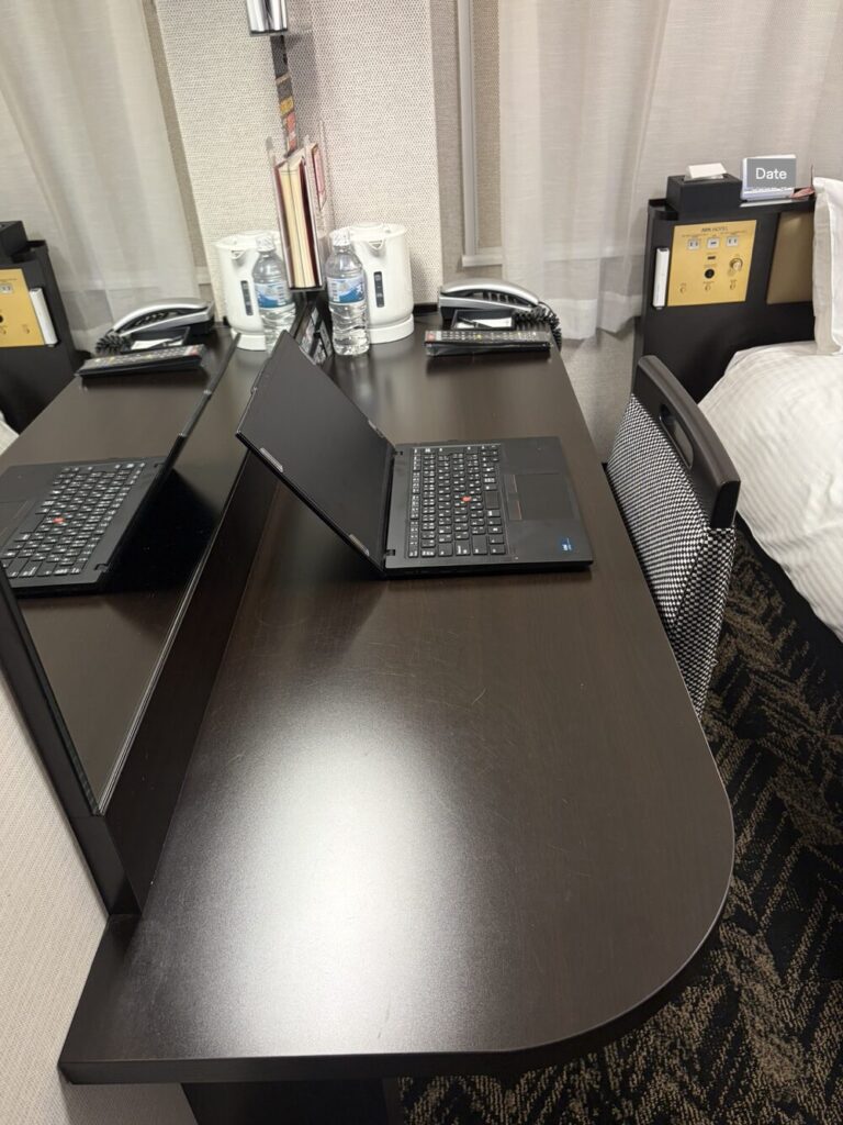 アパホテルのデスクに14インチのノートPCだけを置いた奥行きとサイズ感
